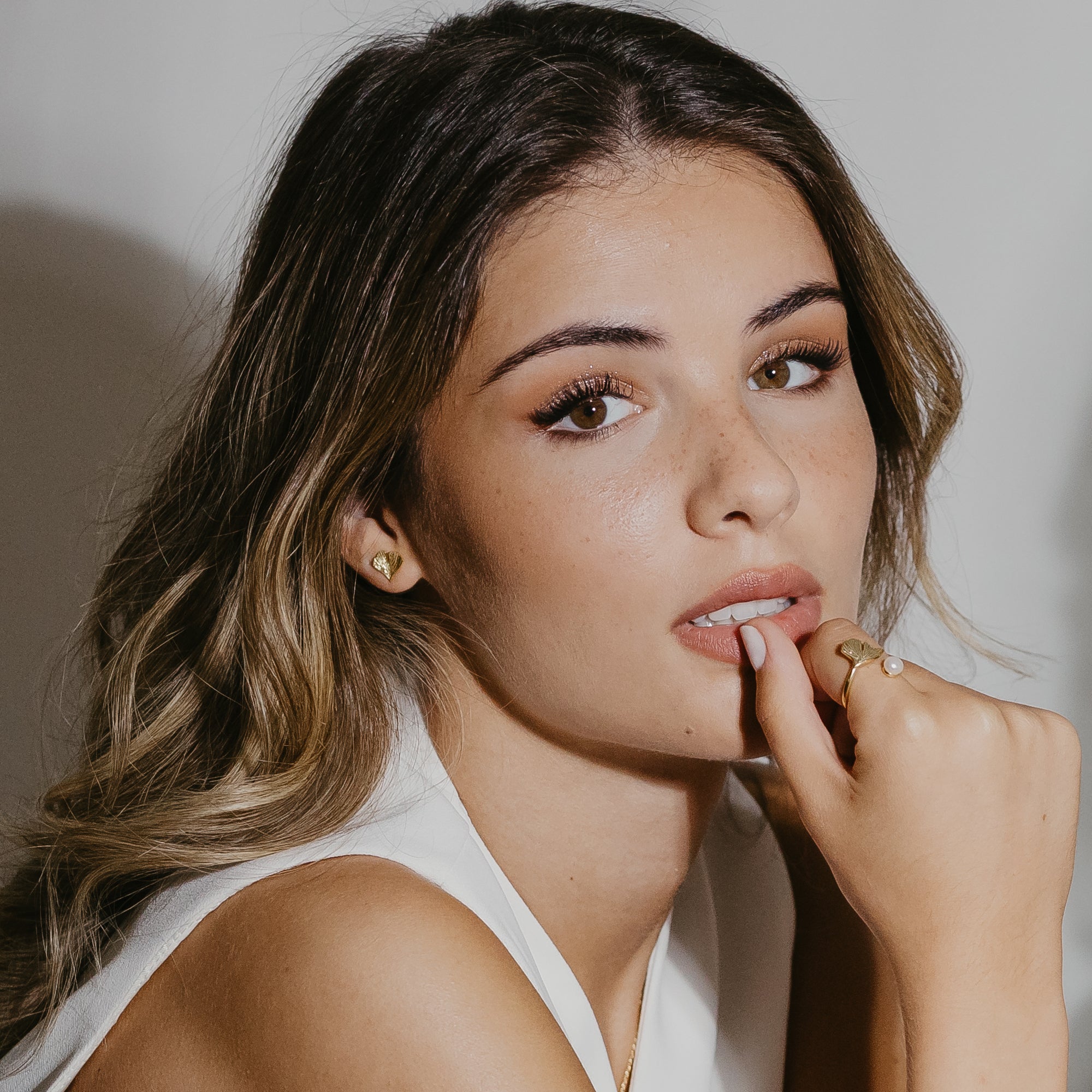 Ginkgo leaf stud earrings in gold vermeil worn on ear