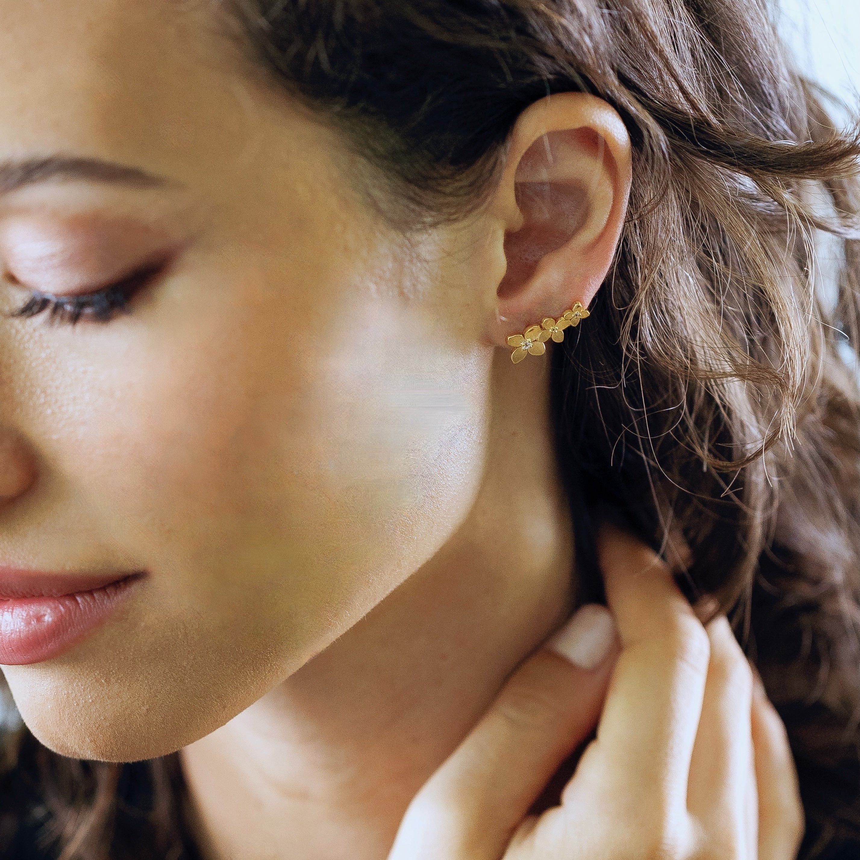 Bloom ear climbers in gold vermeil worn showing petal-shaped cascading design