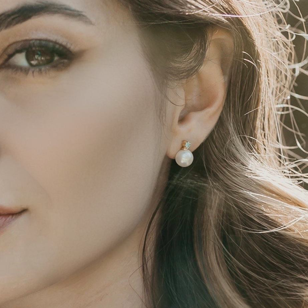 Blue topaz and pearl stud earrings in gold vermeil worn on ear