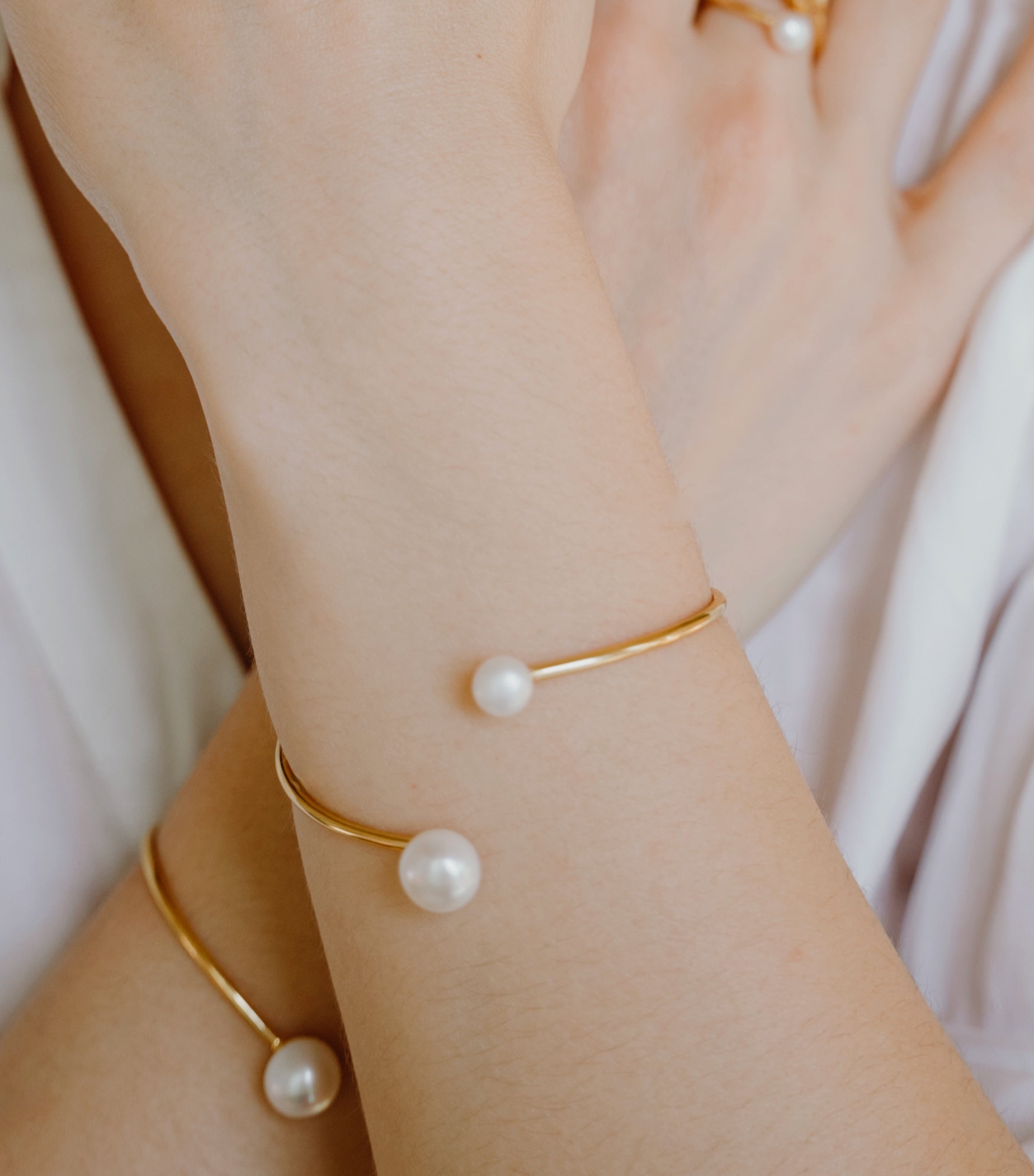 Close-up of pearl cuff bracelet worn displaying two lustrous freshwater pearls