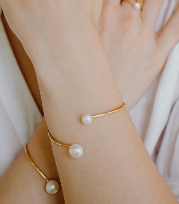 Close-up of pearl cuff bracelet worn displaying two lustrous freshwater pearls