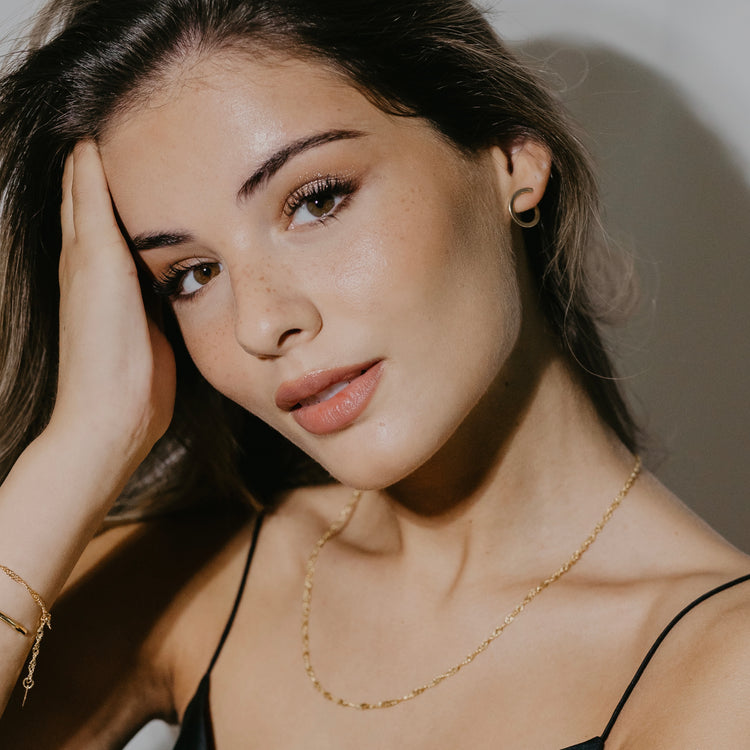 Side view of Sleek twisted hoop earrings worn showing elegant curved shape