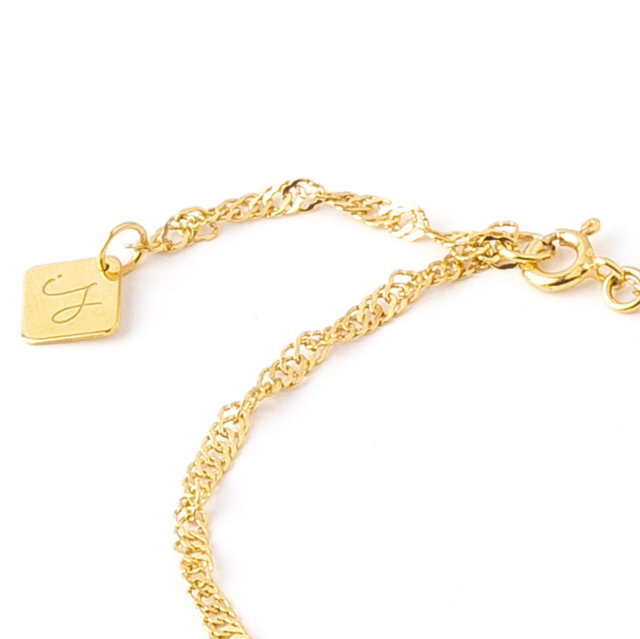 Close-up of twisted chain bracelet showing Inês Santos logo and adjustable clasp detail