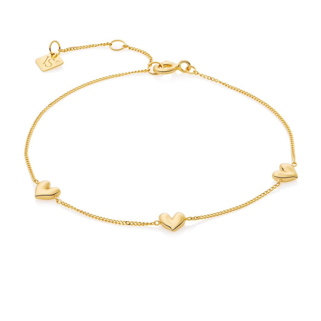 Gold bracelet with heart-shaped charms on a white background