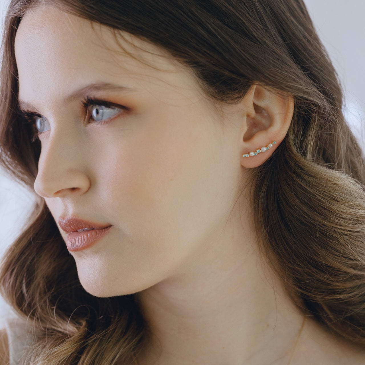 Blue topaz and pearl ear climbers in gold vermeil worn showing cascading design