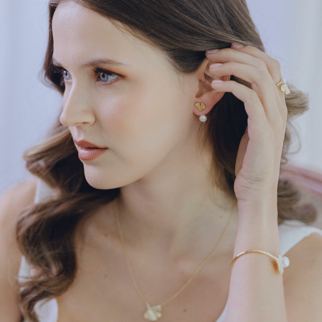 Ginkgo pearl drop earrings styled on ear with adjustable pearl feature