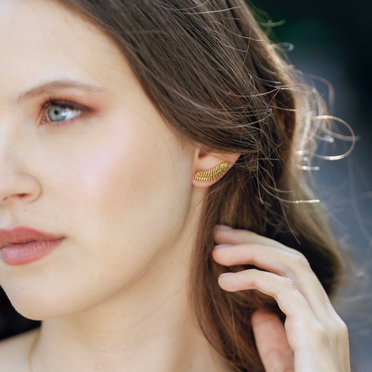 Palm leaf stud and ear climber worn showing botanical design on ear