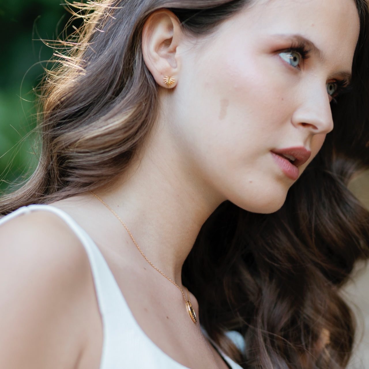 Palm leaf stud earrings in gold vermeil worn on ear