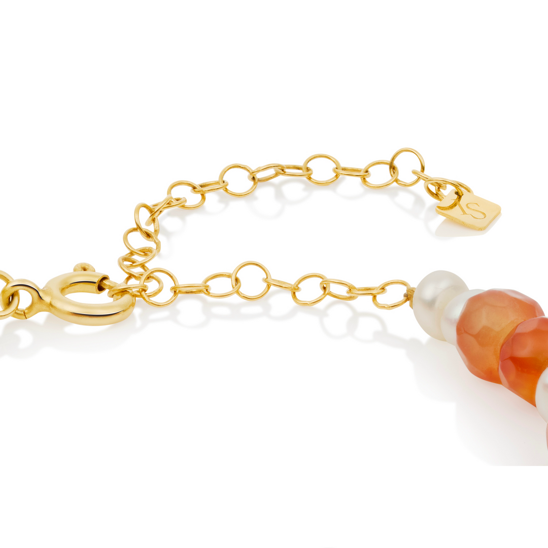 Gold bracelet with beads on a white background