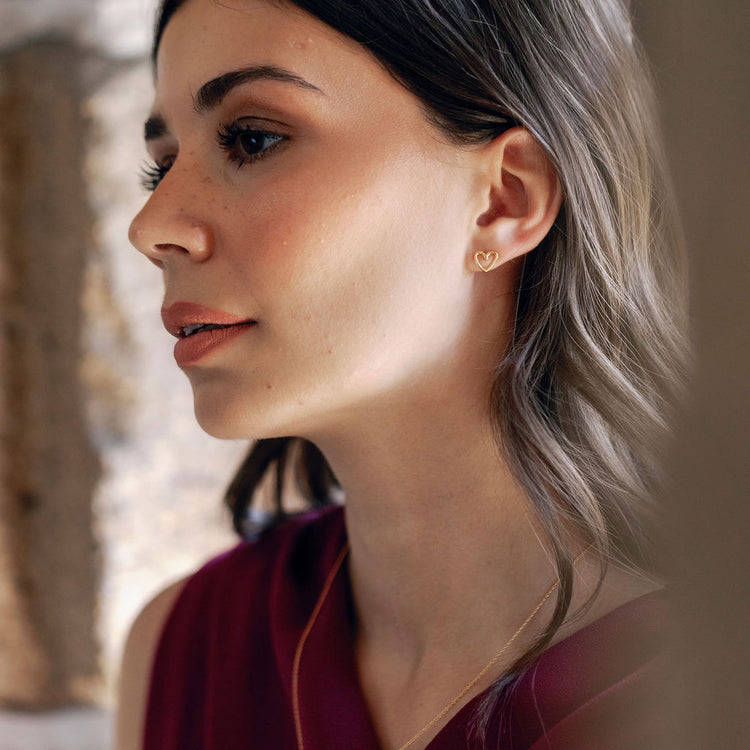 Close-up of a woman wearing heart shaped earrings in a blurred background