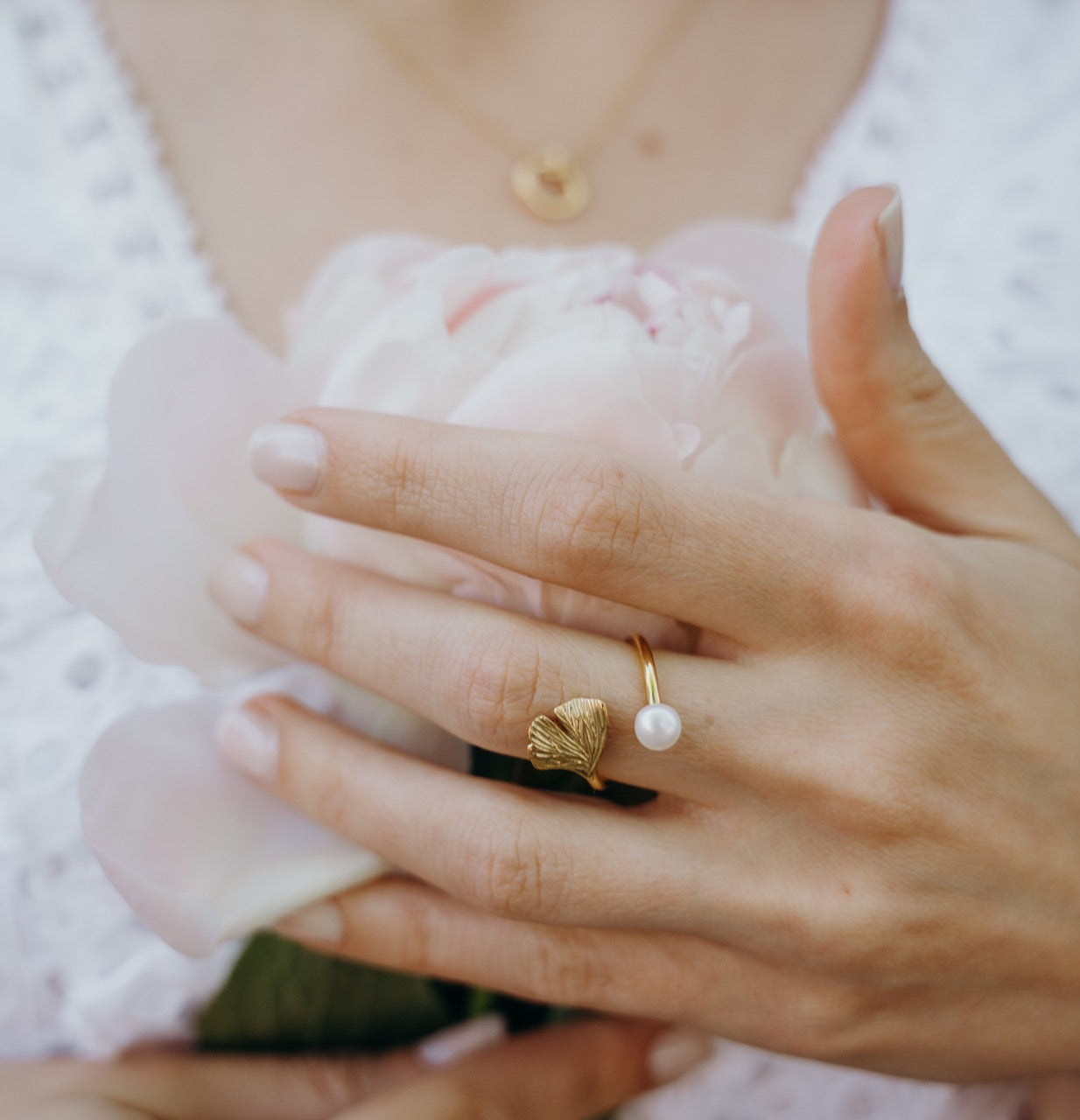 Close-up of Ginkgo ring worn displaying fan-shaped leaf and freshwater pearl combination